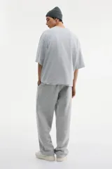 Remera de algodón pesado color gris melange, con cuello redondo ribeteado, hombros caídos y corte oversized.