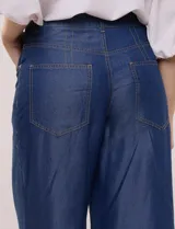 Pantalón wide leg de denim liviano gris, con tiro alto, presillas para cinturón, bolsillos laterales y corte recto de piernas anchas.
