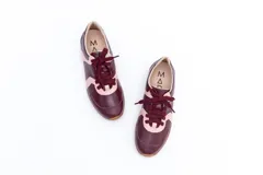 Zapatillas Magnolia de cuero negro con detalles en blanco y suela marrón.