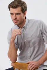 Camisa sport celeste de manga corta con cuello abotonado y bolsillo frontal en el pecho.
