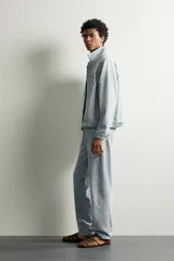 Jeans de corte recto color celeste claro, con tiro medio, diseño de cinco bolsillos, efecto lavado y bajo con acabado irregular deshilachado.