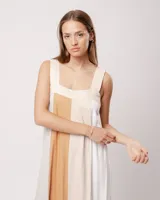 Vestido largo de lino color blanco, gris y amarillo, con breteles anchos, escote recto, elástico en la espalda y tajos laterales.