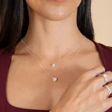 Conjunto de dos collares tipo gargantilla en plata 925, cada uno con un dije de punto de luz con circonia engastada en bisel.