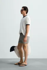 Bañador de hombre color verde claro con finas rayas blancas verticales (efecto seersucker). Tiene cintura elástica ajustable con cordón verde, bolsillos laterales y un bolsillo trasero de vivo.