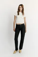 Jeans de tiro bajo y corte recto holgado, con efecto encerado en color negro, cinco bolsillos y trabillas para cinturón. Cierre frontal con cremallera y botón metálico.