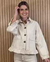Sobrecamisa de pana color crudo, con cierre frontal de botones carey, bolsillos frontales aplicados, cuello camisero, mangas largas y detalle de volado en el ruedo.
