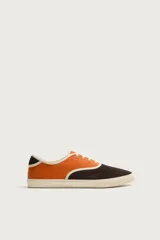 Zapatilla casual de hombre con diseño combinado en color naranja y marrón oscuro, con cordones y suela de goma en contraste.