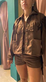 Campera marrón de gamuza sintética con flecos en el frente, la espalda y los brazos.