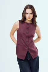 Top estilo chaleco sin mangas, de color bordó, con cuello redondo y cierre frontal con botones oscuros. Presenta bolsillos ojal simulados en la parte inferior del frente.