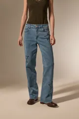 Pantalon de jean azul de corte recto y calce medio, con bordados de estrellas y detalles de pequeñas tachas.