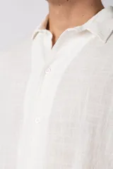 Camisa de manga corta confeccionada en una mezcla liviana de rayón y lino color blanco. Presenta un diseño de calce regular con cuello plano, botones frontales y un estampado artístico en la espalda inspirado en el sol.