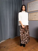 Pollera midi plisada de terciopelo con estampado animal print. Presenta un corte acampanado y fluido.