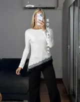 Blusa de manga larga color marrón, con corte asimétrico y detalle de puntilla blanca en el ruedo. Confeccionada en tejido de algodón y viscosa.