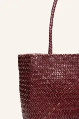 Cartera tote de cuero vacuno trenzado a mano, color bordó, de diseño espacioso con asas firmes.