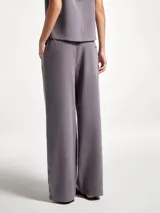 Pantalón de tiro medio color gris, de corte recto y holgado, con cintura elástica y aberturas laterales en el ruedo con detalle de franja en contraste.