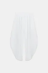 Pantalón confeccionado en lino 100%, de tiro medio con cintura elástica ajustable mediante cordones y bajo redondeado con aberturas laterales.