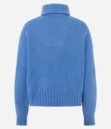 Suéter de punto azul con cuello alto y cierre frontal de cremallera metálica. Presenta textura de líneas verticales, corte regular, mangas largas y terminaciones acanaladas.