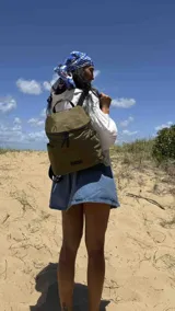 Mochila urbana de diseño compacto en color negro, confeccionada en nylon resistente. Cuenta con un compartimento principal con cierre, bolsillo frontal con cierre y correas ajustables con detalle de marca.