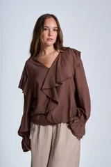 Blusa de color marrón con escote en V, mangas largas abullonadas con puños elásticos y detalles de volados en los hombros y el frente.