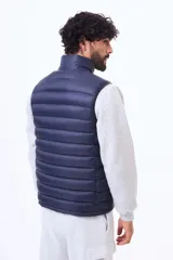 Chaleco acolchado negro con cierre frontal completo y cuello alto. Diseño ligero y sin mangas, ideal para superponer capas.