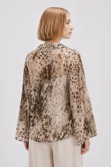 Blusa de poliéster de corte holgado con cuello en V, mangas largas acampanadas y estampado abstracto multicolor en tonos marrones y beige.
