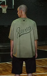 Remera de manga corta, cuello redondo y calce oversize, color verde militar con efecto batik artesanal. Presenta un parche o estampado en el pecho con el número "90".