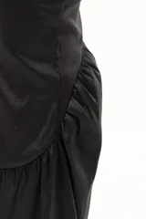 Pantalón de tiro medio con silueta oxford, ajustado en la parte superior y con bajo acampanado. Presenta bolsillos laterales, cierre frontal con cremallera y un detalle fruncido a la altura de la rodilla que aporta volumen.