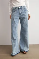Jean wide leg de tiro medio con diseño bicolor, confeccionado en denim de lavado celeste con detalles de costuras y paneles en contraste. Cuenta con botamanga desflecada.