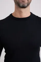 Sweater de punto liso, color azul, con escote redondo y manga larga.