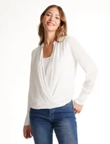 Blusa de gasa blanca, marca Catherine Malandrino, con cuello a la base y escote en V pronunciado. Incluye una pieza interna a tono para un escote discreto. Tiene manga larga con puño ancho y botón.