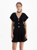 Pollera mini tejida de color negro, con diseño de líneas verticales en relieve y estructura firme.