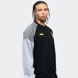 Buzo negro con mangas grises, cuello redondo y puños y cintura acanalados. Presenta el escudo del Club Atlético Peñarol y el año de fundación bordados en amarillo.