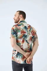 Camisa de manga corta con estampado botánico de hojas en tonos azul y blanco. Presenta cuello clásico, cierre frontal abotonado y corte slim.