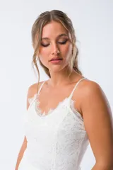 Body blanco de encaje con breteles finos y escote en V con terminaciones de puntilla.