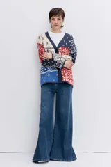 Cardigan de punto con diseño jacquard estilo patchwork en tonos azul, rojo y crema. Presenta un estampado tipo bandana, cuello en V, cierre frontal con botones y mangas largas.