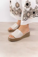 Sandalia de cuero color dorado con textura de piel de serpiente, con faja ancha sobre el empeine con elástico interno, suela de microporosa de alta densidad, taco de 5 cm y plataforma de 2 cm.