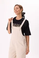 Enterito largo color beige, de corte holgado, con tirantes anchos regulables y bolsillos laterales.