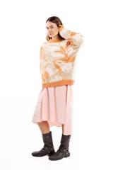 Buzo de tejido jacquard con diseño de formas orgánicas en tonos naranja y beige, de calce relajado, cuello alto y terminaciones tejidas en rib.