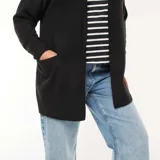Chaqueta larga de punto color negro, con frente abierto, mangas largas con puños acanalados y dos bolsillos frontales aplicados.