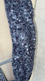 Top con escote halter y espalda descubierta, confeccionado en tela con lentejuelas azules.