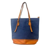 Cartera tipo tote de tela denim azul con base y detalles en cuero sintético color suela. Cuenta con doble asa de hombro y correas decorativas con hebillas metálicas en el frente.