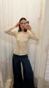 Remera de manga larga en tejido de punto fino y semitransparente, con cuello redondo y ajuste al cuerpo.