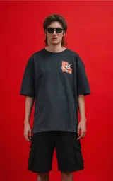 Remera de calce oversize color carbón, confeccionada en algodón premium. Presenta cuello redondo, mangas cortas y un pequeño estampado gráfico de Mickey Mouse en el pecho.