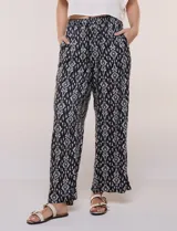 Pantalón wide leg de calce holgado y caída fluida, color negro con estampado de arabescos blancos. Cuenta con cintura elastizada fruncida con lazo ajustable, terminaciones en canutillo de madera y bolsillos laterales funcionales.