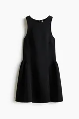 Vestido corto negro sin mangas, con escote redondo, cuerpo entallado y falda acampanada con frunces caídos sobre la cadera.