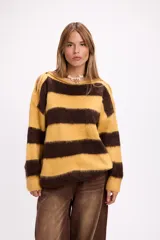 Buzo de tejido de punto con diseño de rayas horizontales anchas en color amarillo y marrón. Presenta cuello redondo, corte holgado y detalle de aberturas en los hombros.