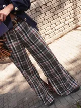 Pantalón a cuadros de corte ligeramente oxford, con cierre y elástico en la cintura, detalle de triángulo de cuero en la pretina y logo bordado en la pierna.