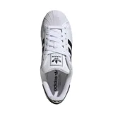 Championes Adidas Superstar de diseño clásico, con capellada de cuero blanco, icónica puntera de goma tipo Shell Toe y las tres bandas laterales en color negro. Presenta detalle en negro en el talón con el logo de la marca.