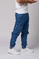 Pantalón jean de corte jogger con bolsillos cargo laterales y puños elásticos en los tobillos.