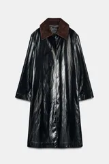 Trench de largo midi con acabado brillante efecto vinilo, manga larga y cuello de solapa en tejido de gamuza a contraste. Presenta cierre frontal con botones ocultos y bolsillos laterales integrados en la costura.